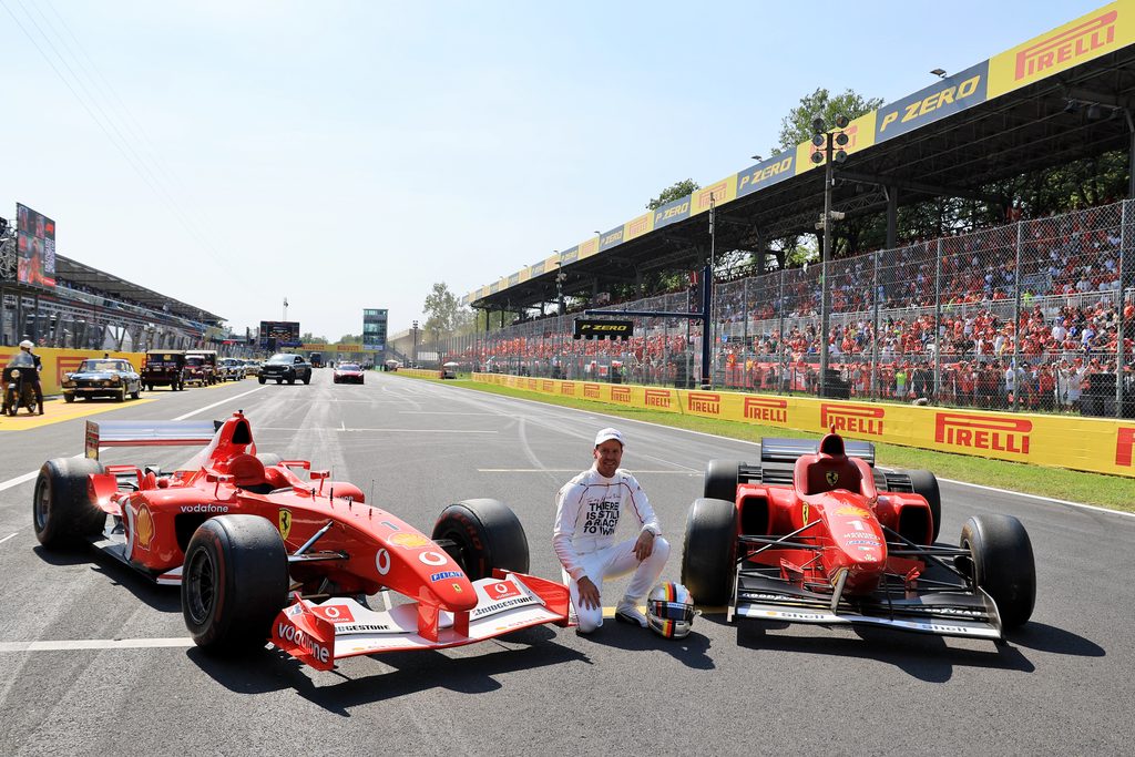 Sebastian Vettel mit zwei Ferrari Autos von Schumacher